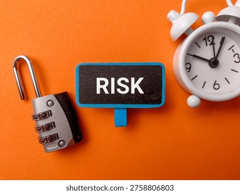 A high-angle conceptual flat lay with the word RISK on a orange background.