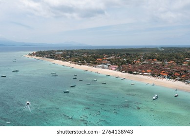 High-angle drone image capturing boats floating near the coast of Nusa Penida, featuring Toya Pakeh and Ped villages in Bali.