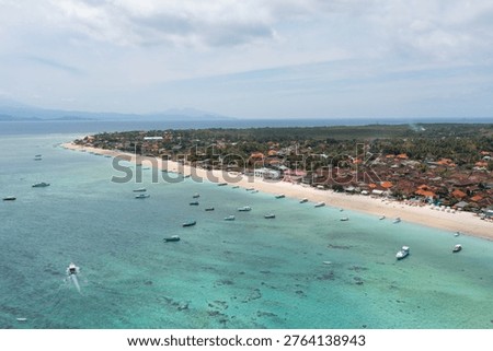 High-angle drone image capturing boats floating near the coast of Nusa Penida, featuring Toya Pakeh and Ped villages in Bali.