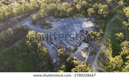 High-angle drone shot of a construction storage site nestled within lush green bushland.