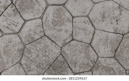 High-angle full-frame shot of a weathered gray stamped concrete floor with an irregular hexagonal stone pattern. The texture shows a rustic, grimy, and aged surface, ideal for background or architectural design concepts.
