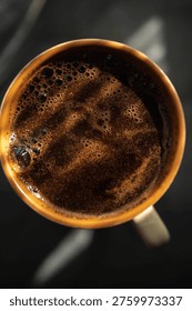 A high-angle macro shot showcasing the surface texture of freshly brewed black coffee or espresso.