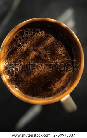 A high-angle macro shot showcasing the surface texture of freshly brewed black coffee or espresso.