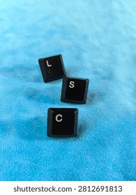 A high-angle, sharp macro photograph featuring three black computer keyboard keys arranged diagonally on a plush, vibrant blue background. The letters 