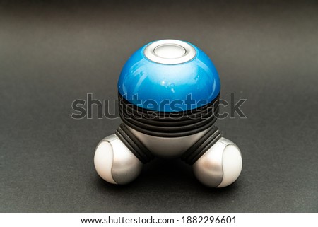 A high-angle shot of a battery-operated mini-massager isolated in the darkgray background