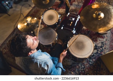 high-angle shot of a drummer man playing in the studio, music band concept. High quality photo - Powered by Shutterstock