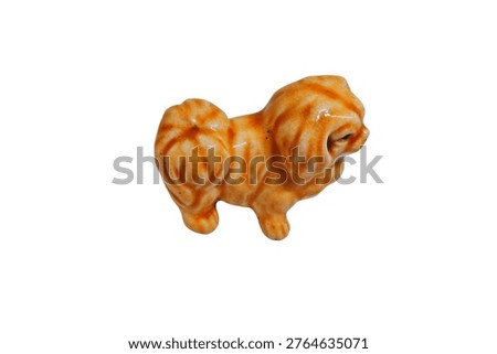 High-angle shot of a glazed ceramic Pekingese figurine showcasing the intricate brown swirling patterns and craftsmanship on a white background.