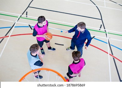 High-angle Shot Of A Gym Teacher Guiding High School Students With A Basketball During A Gym Class.