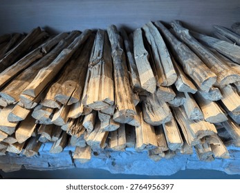 A high-angle shot of neatly stacked, split firewood logs showcasing natural timber grain and textures, perfect for themes of warmth, rustic living, and winter preparation.