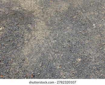 High-angle texture background of a rough dirt road mixed with small gravel and pebbles.
