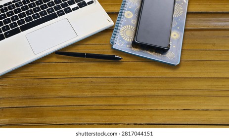 A high-angle, top-down flat lay view of a modern creative workspace on a wooden slatted desk surface.