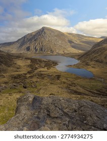 A high-angle, vertical landscape capturing the dramatic glacial valley of Cwm Idwal in Eryri Snowdonia National Park, North Wales
