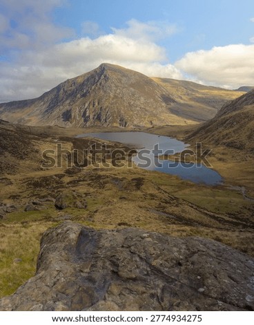 A high-angle, vertical landscape capturing the dramatic glacial valley of Cwm Idwal in Eryri Snowdonia National Park, North Wales