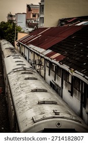 High-angle vertical view capturing the long, cylindrical roof of a stationary train on the tracks. Highlights industrial transportation, rail infrastructure, and travel. Evokes a sense of vintage urba