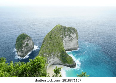 High-angle view of the iconic T-Rex shaped rock formation and turquoise bay at Kelingking Beach in Nusa Penida.