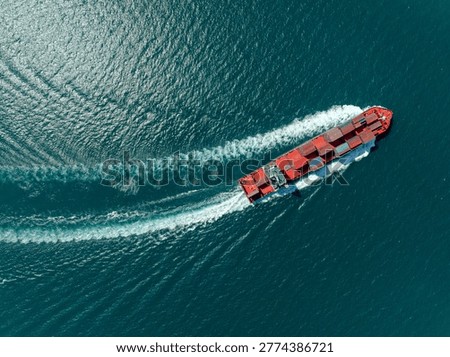 A highangle view of a large container vessel traversing the open sea illustrating global trade logistics and international shipping supply chain operations.