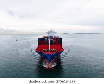 A highangle view of a massive cargo vessel crossing the sea under a cloudy sky representing global trade logistics and industrial supply chain networks.