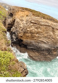 High-angle view of ocean waves churning through a narrow rocky canyon along the dramatic cliffs of the Cantabrian Sea coastline
