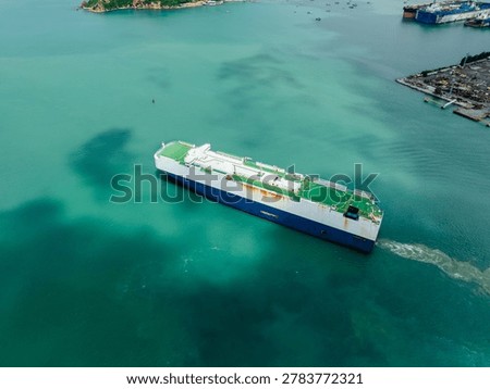 Highangle view of a rollon rolloff cargo vessel moving through turquoise tropical waters near chonburi thailand representing international trade and maritime logistics.
