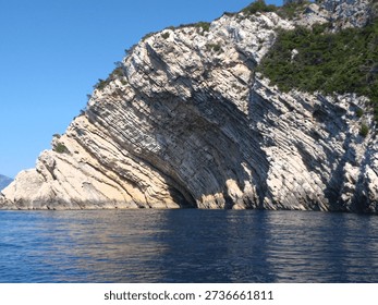 High-angle view of tilted limestone sedimentary strata on the coastal cliffs of Bisevo Island, Croatia. Excellent example of geological stratification and tectonic activity.