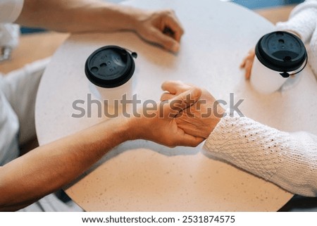 High-angle view of unrecognizable happy elderly couple enjoying each other company having coffee at cafe, demonstrating importance of companionship and connection in later life.