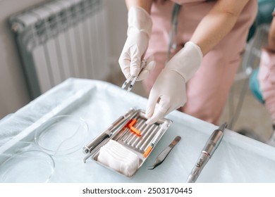 High-angle view of unrecognizable medical practice assistant removing cap from needle of syringe, preparing to operation at hospital. Surgery doctor preparing syringe medicine for procedure in clinic - Powered by Shutterstock