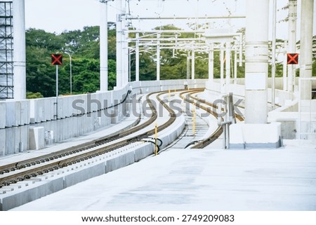High-angle view of winding parallel railway tracks on a modern concrete elevated transit line, showing perspective and infrastructure engineering