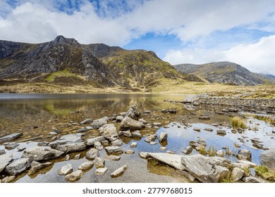 A high-dynamic-range image featuring the ethereal, mist-covered glacial bowl of Cwm Idwal and the still waters of Llyn Idwal. The soft, high-key lighting and atmospheric fog create a serene, dreamlike quality, emphasising the scale and solitude of the Glyderau mountains.