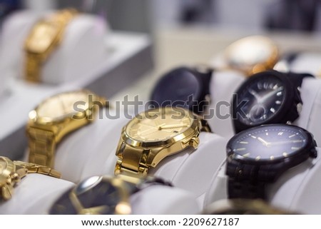 High-end gold-colored watches, exposed behind the window of a watch shop