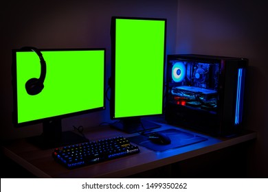 High-end PC Game Rig With Dual Mock Up Green Screen Or Chroma Key Monitor Stands. Modern Design Is Lit With Blue And Neon Light.