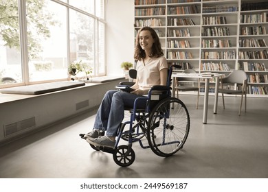 Higher education knows no limits, knowledge without boundaries, skills for all. Smiling optimistic student girl with disability sit in wheelchair smile looking away posing alone in university library - Powered by Shutterstock