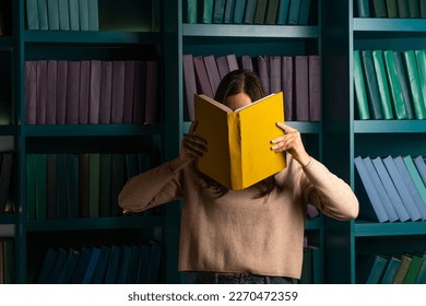 Higher education, training in complex specialties, concept. Natural sciences. A large amount of information. Student in the library against the background of bookshelves, laconic minimalistic style