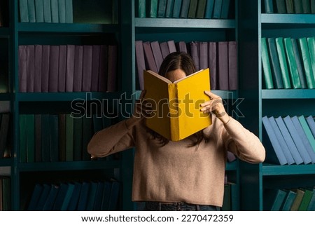 Higher education, training in complex specialties, concept. Natural sciences. A large amount of information. Student in the library against the background of bookshelves, laconic minimalistic style
