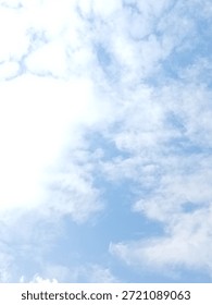 High-key image of fluffy white clouds scattered across a pale blue sky, creating a light, airy and refreshing atmosphere. Ideal for backgrounds, weather concepts, wellness, freedom, calm mood, and minimalist nature designs.