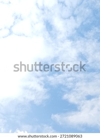 High-key image of fluffy white clouds scattered across a pale blue sky, creating a light, airy and refreshing atmosphere. Ideal for backgrounds, weather concepts, wellness, freedom, calm mood, and minimalist nature designs.