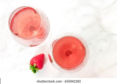 A High-key Overhead Photo Of Two Glasses Of Rose Wine With Strawberries, On A White Marble Texture With A Place For Text. Selective Focus