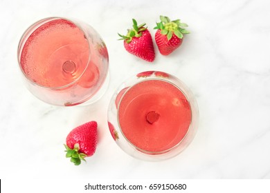 A High-key Overhead Photo Of Two Glasses Of Rose Wine With Strawberries, On A White Marble Texture With A Place For Text. Selective Focus