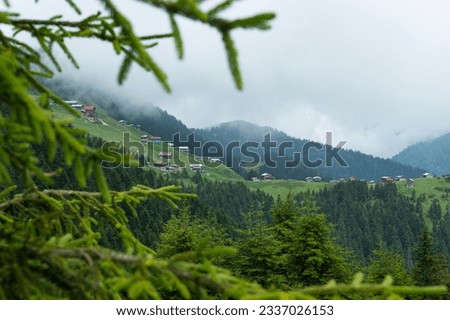 Highland landscape in cloudy and foggy weather. Highland houses made of stone and wood. Wooden plateau houses built on the hill. Wooden plateau houses in Turkey. Pokut Plateau Rize Türkiye.