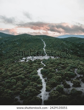The highland pathways of Sardinia, veiled in the soft glow of dusk, lead us through nature's undisturbed concert of colors and sounds. Our Defender, a speck against the vastness, is our steadfast