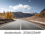 highland road. autumn highway in front of ice peaks.