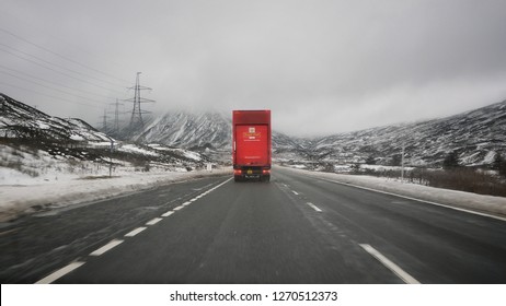 Highlands, Scotland: 18th December 2018 - A Lone Royal Mail Delivery Truck Driving Through The Scottish Highlands In Winter Time, Prior To Christmas.