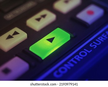 Highlighted play button of a proffesional music controller used on entertainment industry. Video or audio. A color graded, extreme close up shot with selective focus