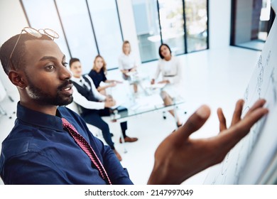 Highlighting The Key Components. Cropped Shot Of A Young Businessman Giving A Presentation In The Boardroom.