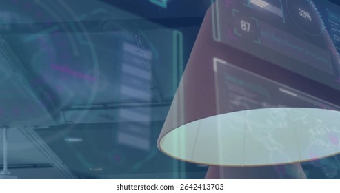 Highlighting modern angled lamp shade casting glow on digital panels inside tech office, copy space. Futuristic, technology, workspace, illumination, interface, data visualization, industrial