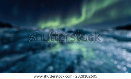 A highly blurred abstract background featuring ethereal green aurora borealis light patterns glowing over a soft, out of focus dark blue landscape with shimmering bokeh highlights.