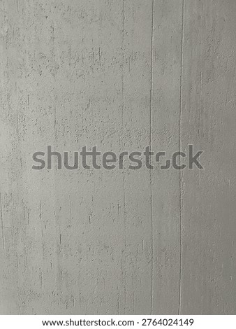 Highly detailed macro shot capturing the tiny granular grit, sand particles, and pitted bumps in grey wall plaster. This extreme close-up highlights the rugged tactile feel of raw industrial building materials.
