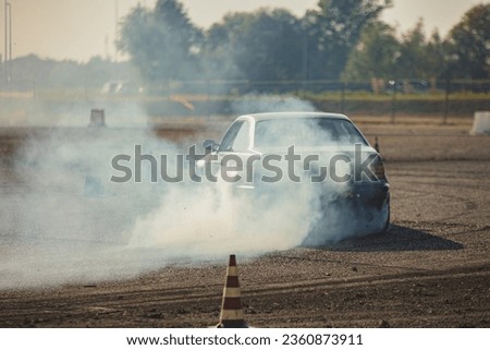 High-octane car drift race captured amidst swirling smoke, showcasing speed and skill.
