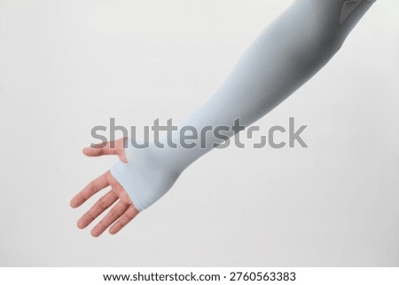 A high-performance black compression arm sleeve with an integrated thumbhole design for a secure, stay-in-place fit. This premium UV-protection cooling sleeve is crafted from sleek, breathable elastic fabric, expertly modeled against a clean, minimalist white background. An essential visual for athletic gear marketing, outdoor sports blogs, fitness apparel catalogs, or health-focused editorial content. The seamless construction and ergonomic palm coverage highlight both comfort and style, making it a perfect asset for showcasing protection during cycling, running, or everyday outdoor activities.