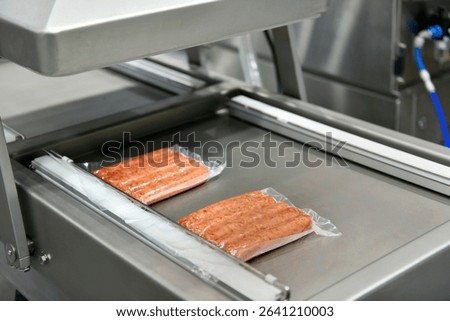 High-performance machines are wrapping processed fresh food products sausages. food production lines on conveyor belts, food production industry