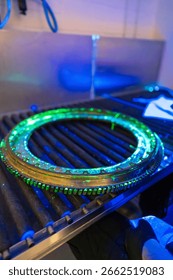 A high-precision aerospace component is undergoing fluorescent penetrant testing with distinctive green indications. Non-destructive evaluation exposes  discontinuities in this critical flight safety 